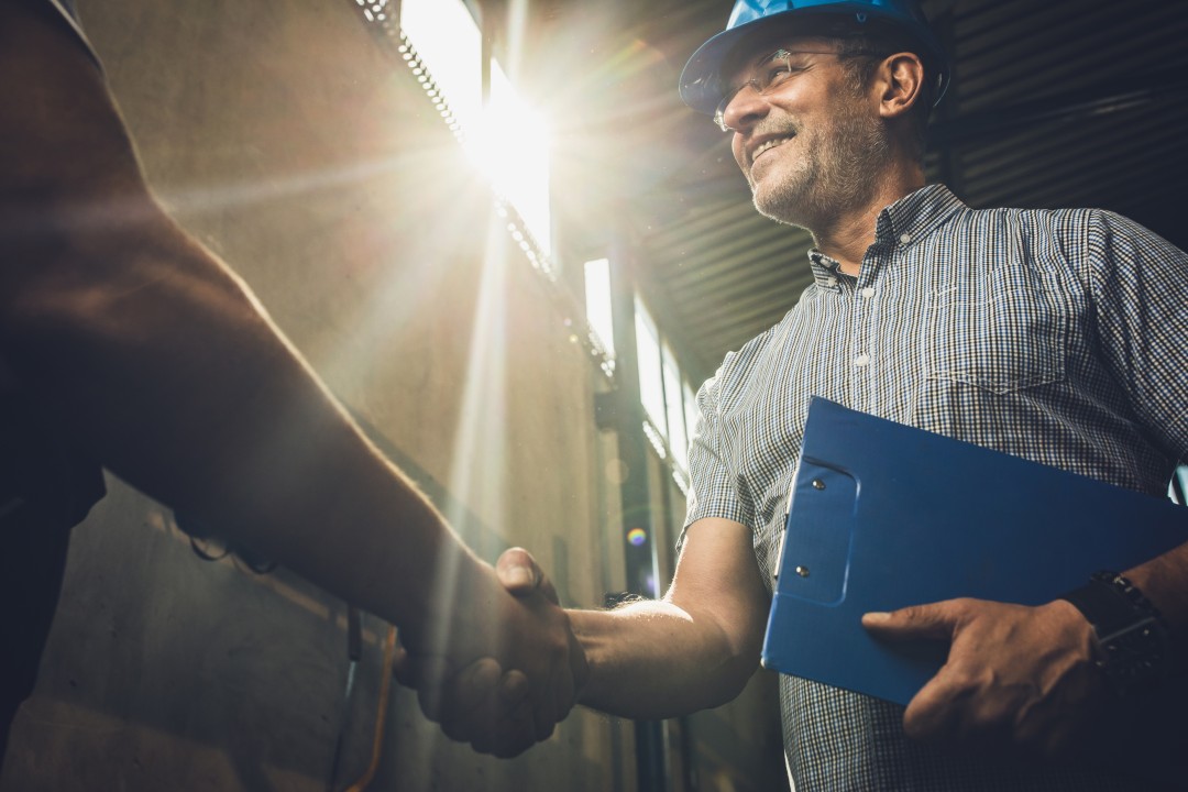 Construction Worker Shaking Hands with Another Employee