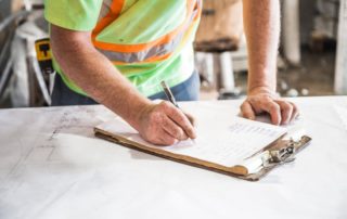 Worker checking something off of checklist on notepad