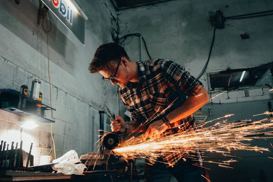 Welder working on piece with sparks flying