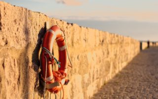 Beach buoy hanging on a cement wall