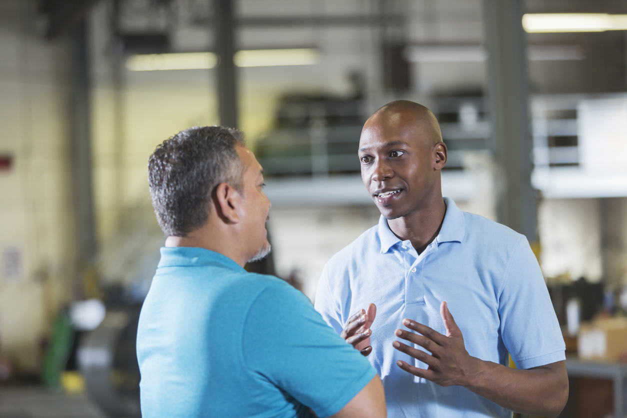 Two workers talking in a workshop