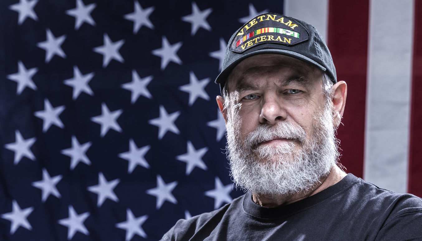 Veteran standing in front of American flag