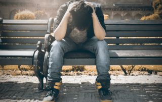 Burned out teenager with head down on bench after work